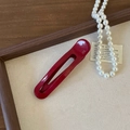 Detailed shot of a deep red acetate hair clip with France Handmade engraving on white background - Red