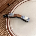 Detail view of a marble pattern bow banana clip hair accessory in a ceramic plate - Ink Wash Style Blue White