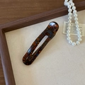 Detailed macro view of a tortoiseshell acetate hair clip with FRANCE Handmade engraving - Blue Brown Gradient