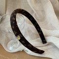 Detail of vintage brown floral headband with gold logo pendant on silk fabric - Coffee Floral