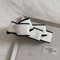Detail of the elegant black and white bow hair clip with plush textured velvet finish - Cream White