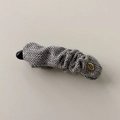 Dettaglio del fermaglio a banana in tessuto a spina di pesce con etichetta dorata - Pinza a Banana Grigio Chiaro