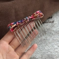 Close-up of a colorful acetate bow hair comb with ten durable silver metal teeth - Marbled Blue