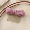 Détail macro du nœud en tricot lavande avec peigne en métal sur assiette en céramique - Rose