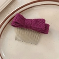 Vue détaillée d'un peigne à cheveux avec nœud en tricot violet sur une assiette décorative - Rose Bonbon