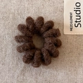 Detailed macro view of dark brown plush spiral hair tie on a minimalist linen background - Brown