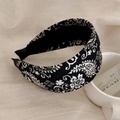 Dettaglio del motivo paisley vintage su una fascia larga che mostra la texture del tessuto - Nero