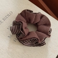 Close-up of brown striped knitted scrunchie hair tie on a decorative book background - Cocoa Brown