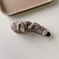 Détail d'une barrette banane en tissu crème à pois noirs avec une texture tricotée élégante - Pince Banane
