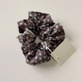 Dettaglio di un elastico marrone con cuori blu e etichetta del marchio Sweety girl - Elastico per Capelli a Pois