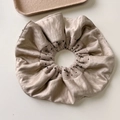 Vue détaillée du chouchou beige à pois avec texture soie et couches de tissu tricoté - Chouchou