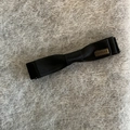 Elegant black satin bow hair clip with vintage metal plate on a soft plush background - Gold Label Style