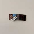 Dettaglio di un fermaglio per capelli in tessuto scozzese marrone con bottoni ed etichetta - Fermaglio BB con Bottone Blu