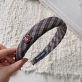 Détail d'un serre-tête en tissu écossais marron avec ornement d'ours et label manuel - Serre-tête à Carreaux Café