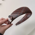 Dettaglio di fascia spessa a quadretti marroni con bottoni decorativi ed etichetta - Cerchietto con Bottone Grigio