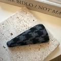 Détail d'une pince à cheveux en laine à motif pied-de-poule sur un bloc de pierre - Triangle / Noir