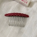 Detail van vintage rode haarkam met witte stippen en tien zilveren metalen tanden op stof - Stippen Haar Insteekkam / Rood