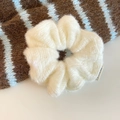 Close-up of a soft white knitted mohair scrunchie showing fluffy texture and fabric detail - White