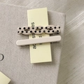 Detail von beigen Polka-Dot- und cremefarbenen Haarspangen aus Harz auf Karton - Cremeweiß
