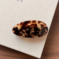 Close-up of marble pattern acetate oval hair clip with gold Barrette la France logo - Amber