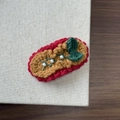 Detail of handmade knit hair clip with vintage red yarn and white faux pearl accents - Christmas Green Bow