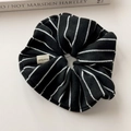 Close-up of black and white striped knitted scrunchie with handmade fabric label - Black Large