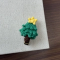 Close-up of handmade knitted Christmas tree hair clip with festive crochet texture details - Christmas Star Tree