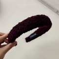Detalle de la diadema de lana de cordero burdeos con etiqueta artesanal y textura suave - Fucsia