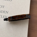 Detail of tortoise shell acetate banana hair clip on vintage book and wooden surface - Blue Brown Gradient
