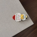 Detail of a handmade crochet Christmas hair clip with a red hat and yellow bow on metal - Snowman