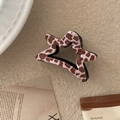 Dettaglio del fermaglio per capelli a stella con trama a macchie marroni e bianche - Stampa leopardata