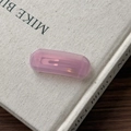 Macro shot of a pink acetate hair clip with a gold-tone metal clasp on a textured book - Pink