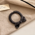 Detail of elegant black satin bow scrunchie showing silky texture and pleated design - Brown