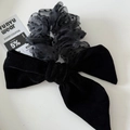 Dettaglio di elastico in velluto nero con fiocco in rete a pois per capelli - Scrunchie con Fiocco