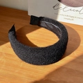 Close-up of black velvet padded headband on a wooden surface with natural light - Black