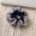 Detailed close-up of retro lace embroidery and blue cable knit texture hair scrunchie - Gray Blue