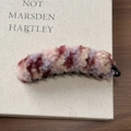 Gros plan d'une barrette banane en peluche sur un livre montrant la texture douce - Rose Violet