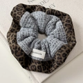 Close-up of leopard print fabric and grey knit texture with a Handmade label on scrunchie - Gray Leopard Scrunchie