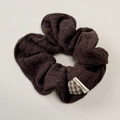 Gros plan détaillé du chouchou en tricot marron foncé avec patch cœur à carreaux et étiquette - Chouchou Café Foncé
