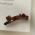Close-up of tortoise shell cat hair clip with small crystals and a black bow accent - Coffee Gradient