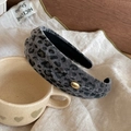 Detalle de diadema con estampado de leopardo gris y adorno metálico dorado - Estilo Leopardo Gris