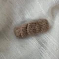 Détail d'une pince à cheveux en tricot caramel chaud avec texture en laine douce - Café Clair