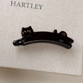 Detailed view of handmade cat-shaped acetate hair clip with sparkling rhinestone eyes - Black