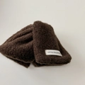 Détail d'une pince à cheveux en peluche marron avec étiquette Little Freshness blanche - Marron