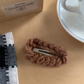 Gros plan d'une barrette en tricot marron en laine épaisse avec un design tissé ovale rétro - Marron