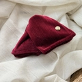 Detailed shot of dark red velvet hair claw clip with a round golden handmade metal tag - Red Triangle Claw Clip