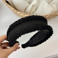 Close-up of thick black knitted headband with textured cable stitch and padded inner band - Black