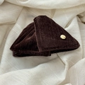 Close-up of deep brown velvet hair clip with a round golden metal logo plaque - Coffee Triangle Hair Clip
