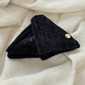 Close-up of velvet fabric with silver metallic threads and a gold handmade label - Black Triangle Claw Clip