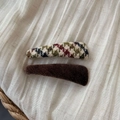 Close-up of vintage brown knit plaid and plush faux fur hair clips on white fabric - Coffee Triangle